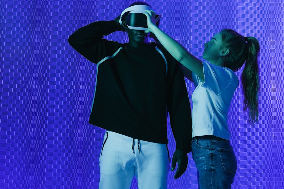 Man wearing virtual reality headset aided by woman in modern studio setting under blue lighting.